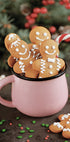 a pink mug filled with cookies and candy canes