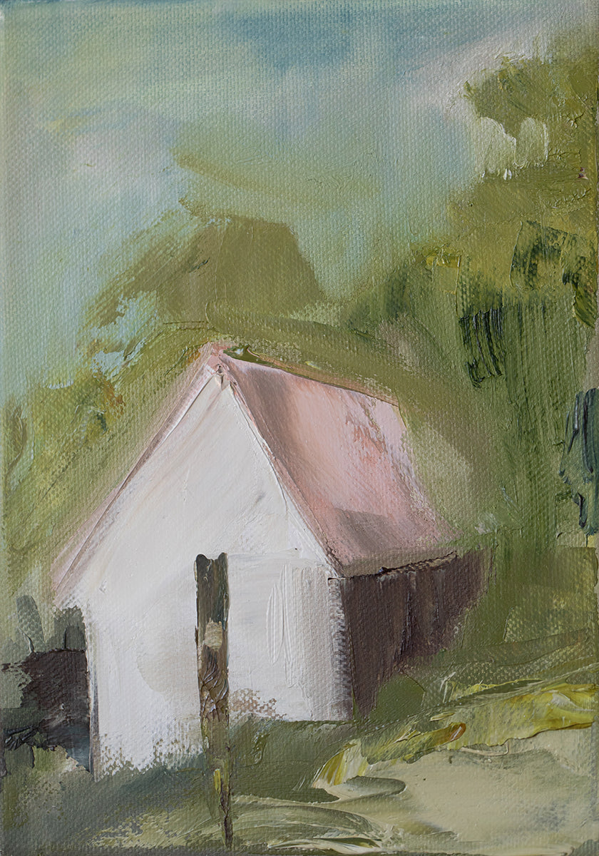 a white house with a pink roof, set against a lush green landscape with trees and foliage.